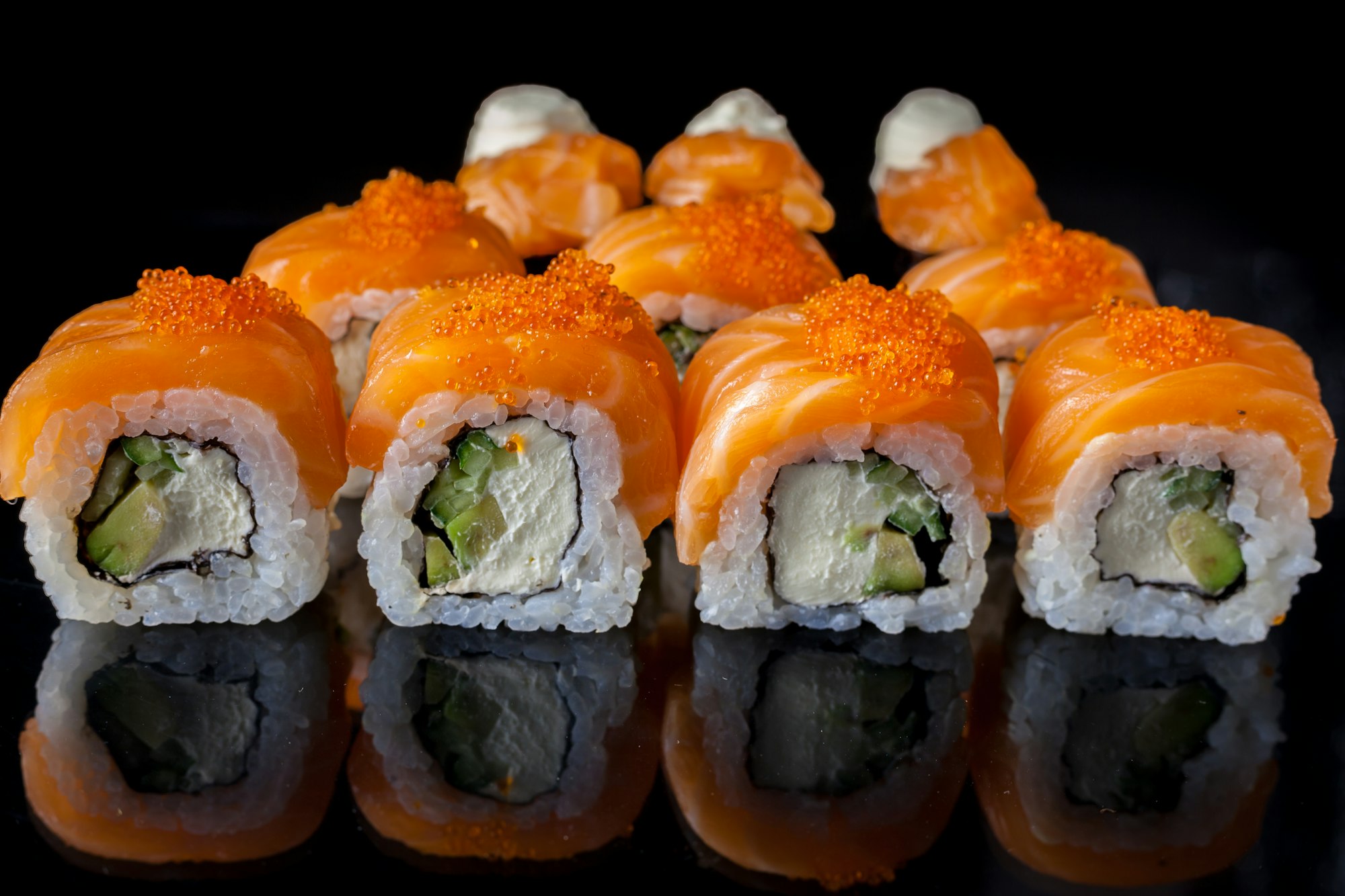 Salmon sushi set. Sushi roll Philadelphia with red fish, salmon, red caviar. Roll with soft avocado